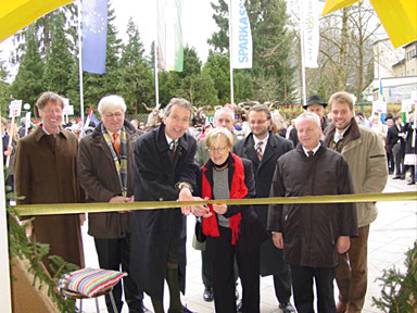 it is the solemn but relaxed moment of the ‘cutting of the ribbon’ by Christiane Keller and Klaus Enengl, surrounded by dignitaries.