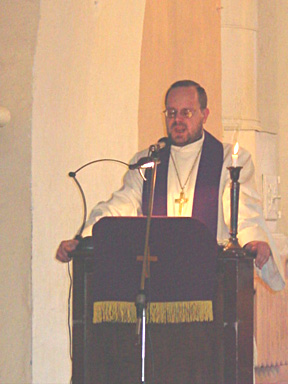 The Reverend Veikko Vihuri speaks to his muffled congregation