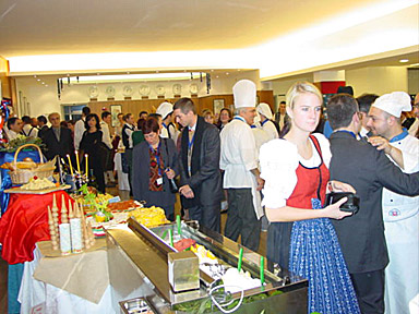 Guests crowd around each delegation’s buffet. Before feasting, they feast their eyes .. 