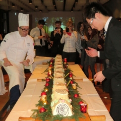 La bûche géante va être découpée pour le dessert de la soirée.