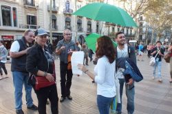 La Rambla discovered by the visitors under the supervision of a guide carrying a green umbrella