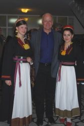 John Rees Smith flanked by pretty girls in traditional dress